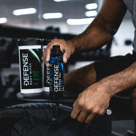Athlete post-workout shower using Defense Soap Tea Tree Body Wash for odor control.