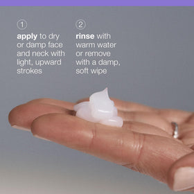 Hands massaging face with cleanser using gentle upward strokes