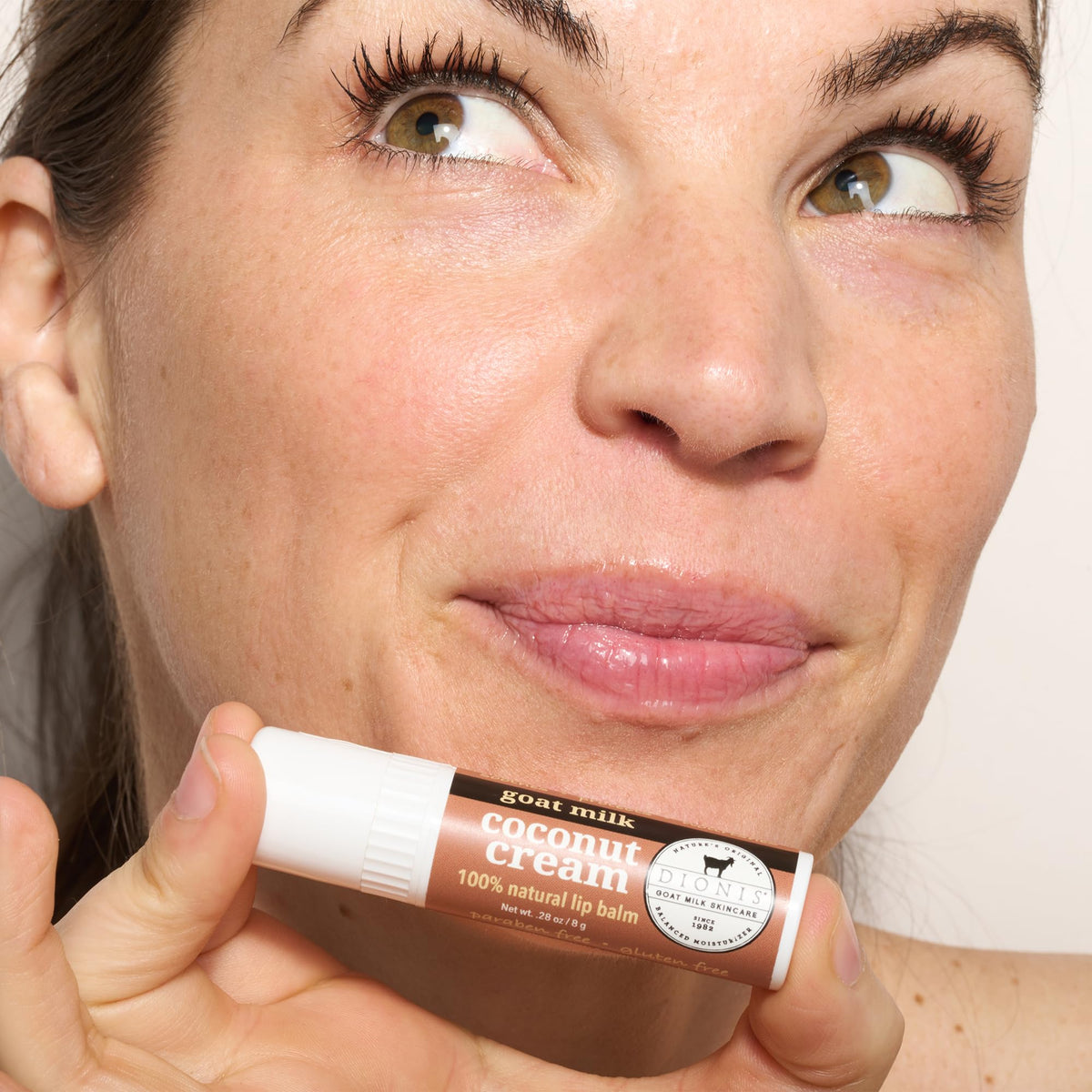 Dionis coconut cream lip balm application demonstrates smooth, non-greasy hydration.