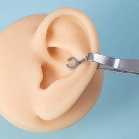 DJCIW ear piercing clamp precision positioning demonstrates accurate placement for cartilage piercings.