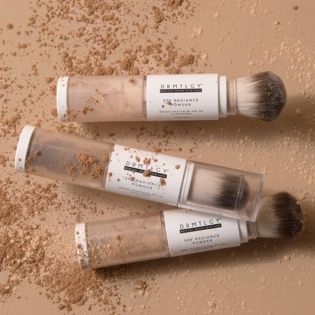 DRMTLGY SPF Radiance Powder tan swatch on skin blending seamlessly.
