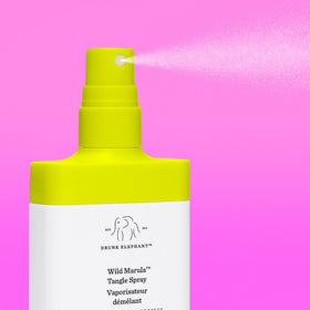 Drunk Elephant Wild Marula Tangle Spray being applied to damp hair for detangling.