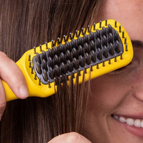 Drybar Baby Brush Crush Mini used on a hair section to smooth and guide shine.