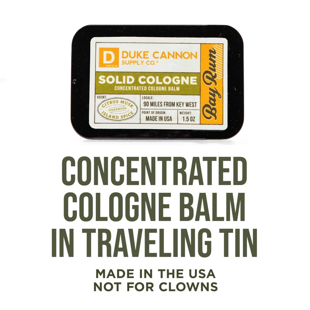 Duke Cannon Bay Rum solid cologne balm on fingertip for precise application.