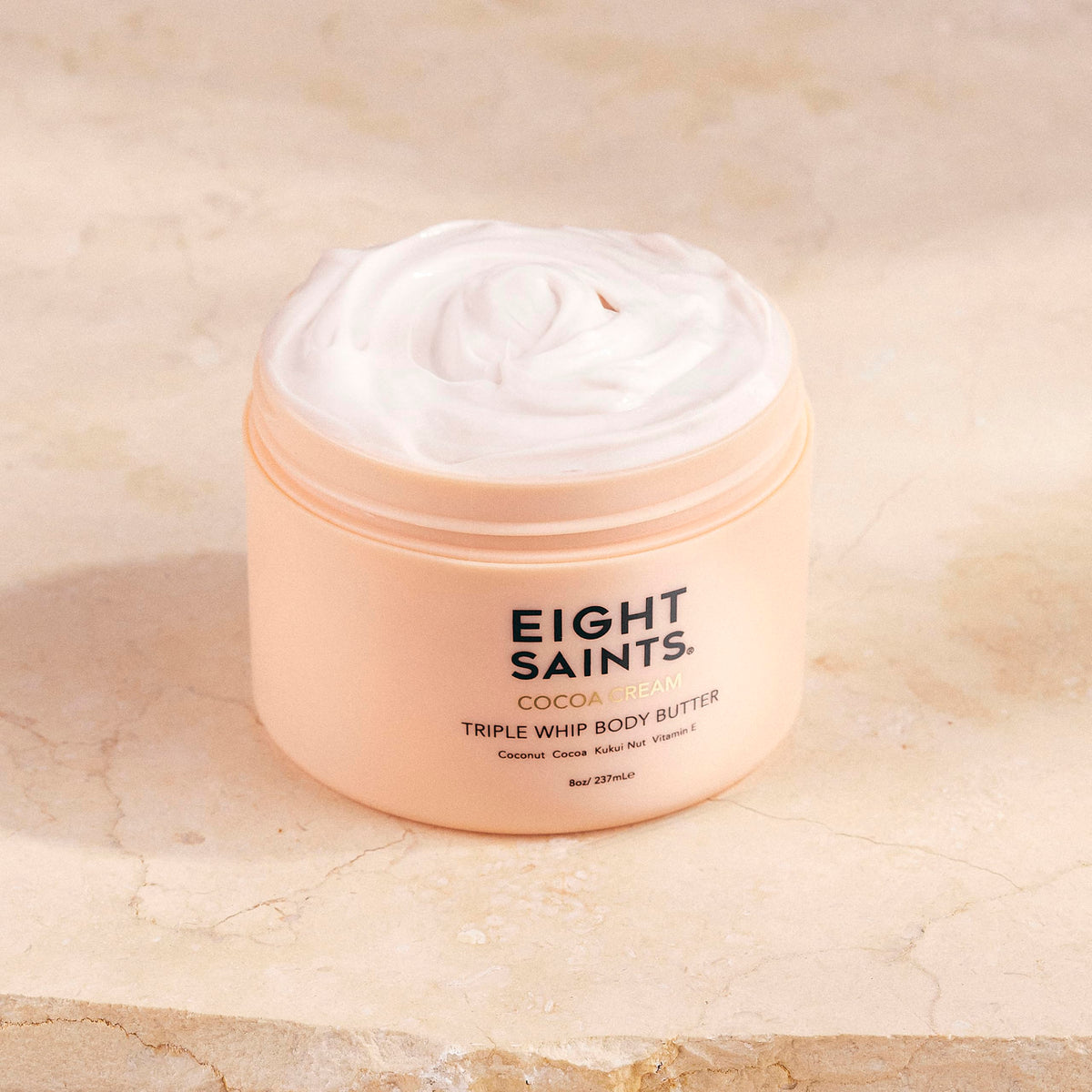 Eight Saints Cocoa Creme jar close-up, rich texture for moisturized skin.