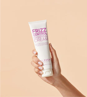 Twisting damp hair sections to reveal curl definition with ELEVEN AUSTRALIA Frizz Control Cream.