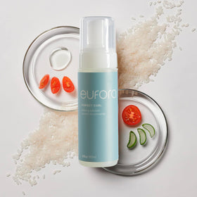 Hands applying Eufora Perfect Curl Defining Solution for defined, frizz-free curls.