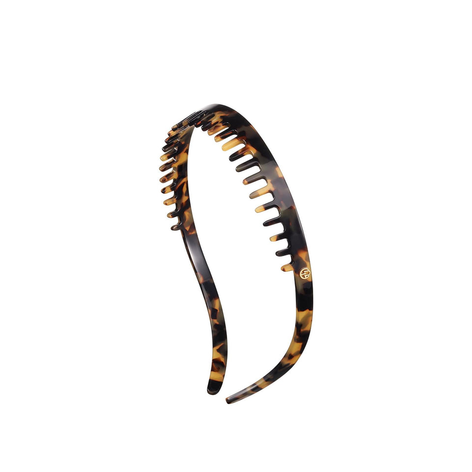 EVITA PERONI toothed non-slip headband securing hair in place.