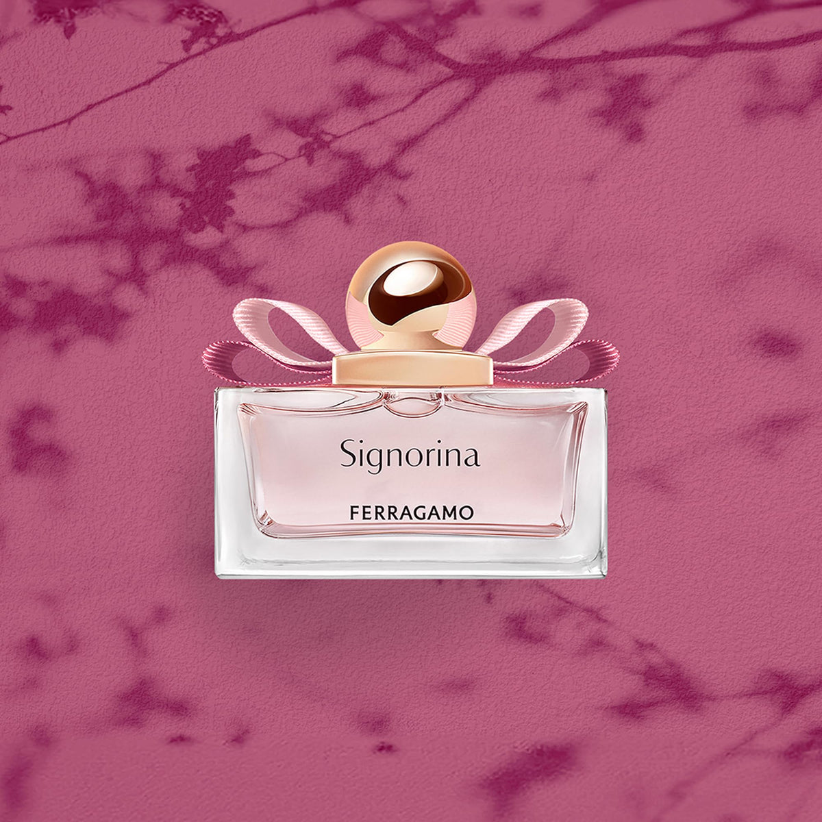 Ferragamo Signorina EDP glass bottle with pink liquid close-up.