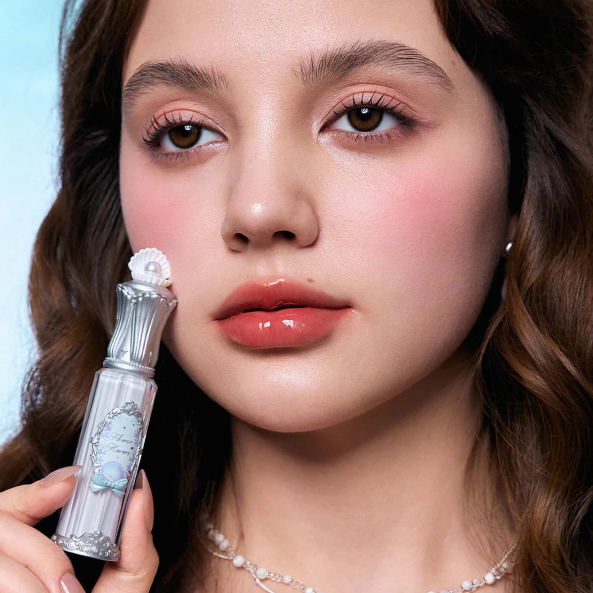 Flower Knows Shells Jewel Nourishing Lip Glaze coral-conch shade on lips with glow