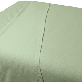 Sheet laid on massage table in sage offers warmth and comfort during long sessions.