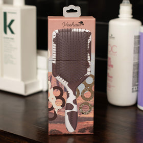 Framar paddle detangler cow-print detail shot showcases stylish portable hair tool.
