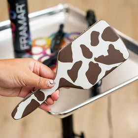Framar paddle detangler handle closeup shows ergonomic grip for secure brushing.