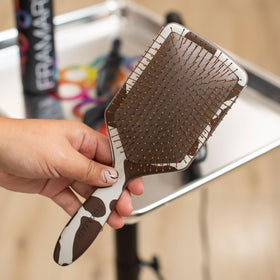 Framar paddle detangler smoothing view demonstrates glide-through detangling on tangled hair.