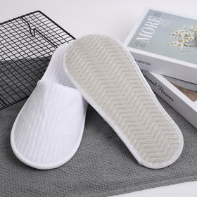 Frcctre hotel spa slippers ready for packing in a travel bag.