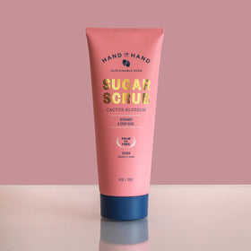 Hand in Hand Sugar Scrub bottle close-up with sunflower oil glow