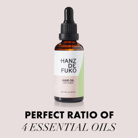 Hands applying Hanz de Fuko vegan oil to damp hair for soft shine