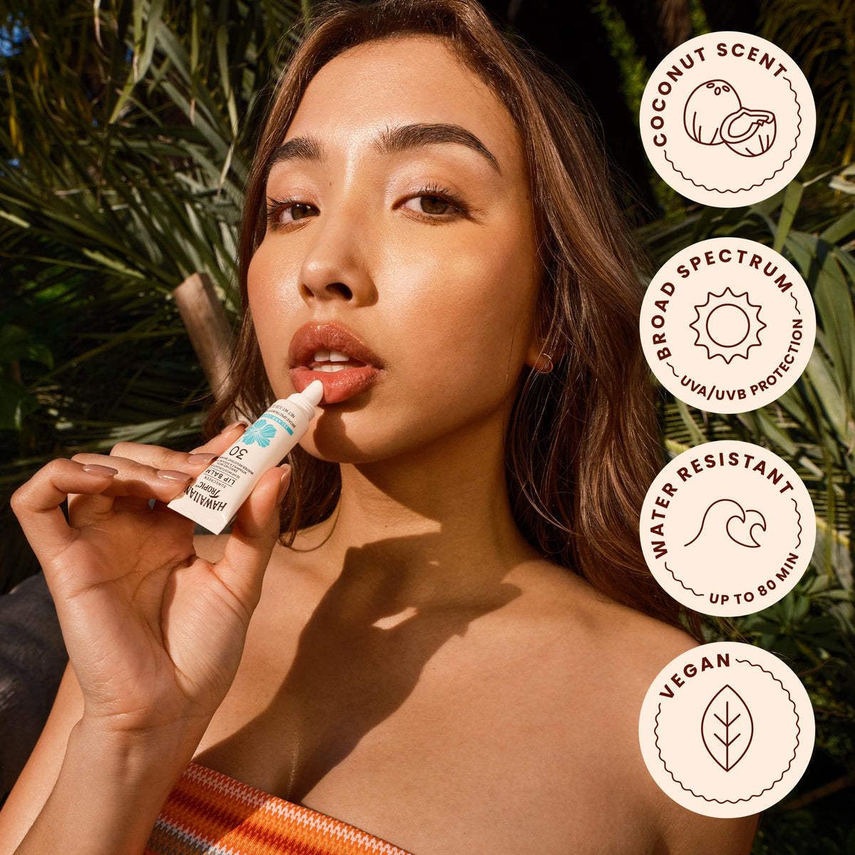 Hawaiian Tropic lip balm Island Coconut with vitamin E sits on beach bag ready for travel