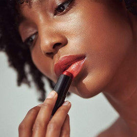 Close-up of applicator applying Henné Organics lip tint.