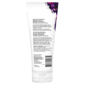 Hands applying Herbal Essences Totally Twisted Gel to damp curls