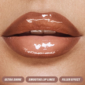 Huda Bombshell lip gloss swatch captures pinky-brown depth and shine.
