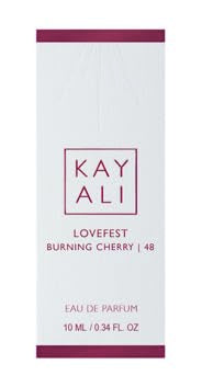 Huda Lovefest Burning Cherry spray application showing fragrance delivery