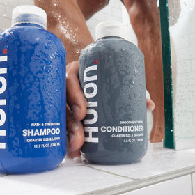 Huron conditioner bottle on sink with smooth, manageable hair in background