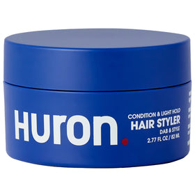 Huron Hair Styler bottle demonstrates compact, travel-ready packaging for quick on-the-go styling.