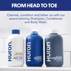 Huron Shower Kit shampoo bottle close-up highlighting cleansing formula for refreshed hair.