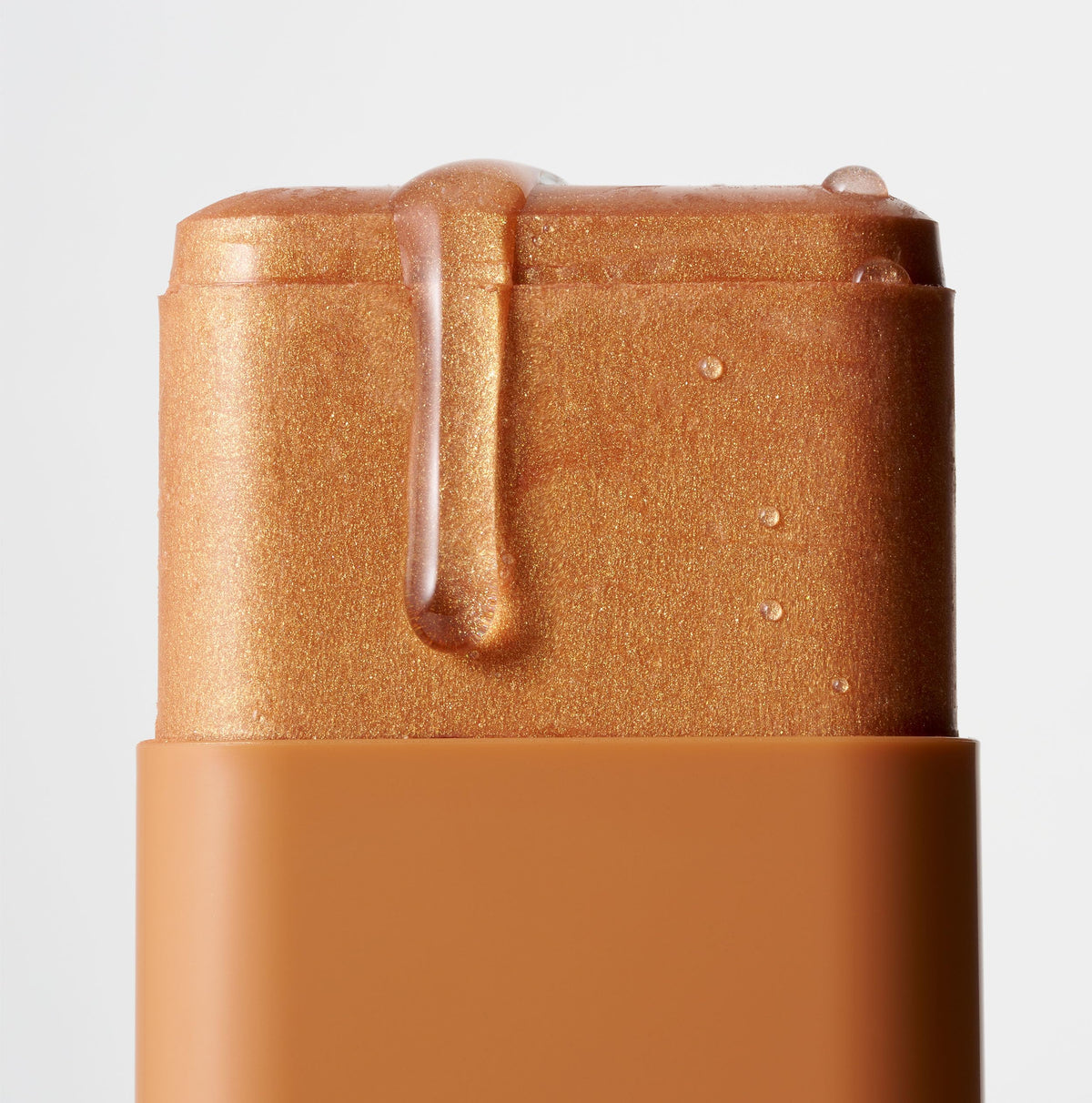 Iconic London Glow All Over Melting Balm Stick on collarbone adds sun-kissed glow.