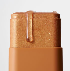 Iconic London Glow All Over Melting Balm Stick on collarbone adds sun-kissed glow.