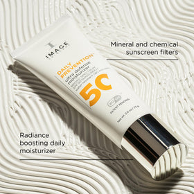 Hands applying IMAGE Skincare DAILY PREVENTION SPF 50 on the skin for even coverage.