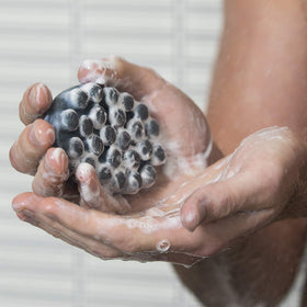 Jack Black Charcoal Body Bar lathers with exfoliating jojoba beads for smoother skin