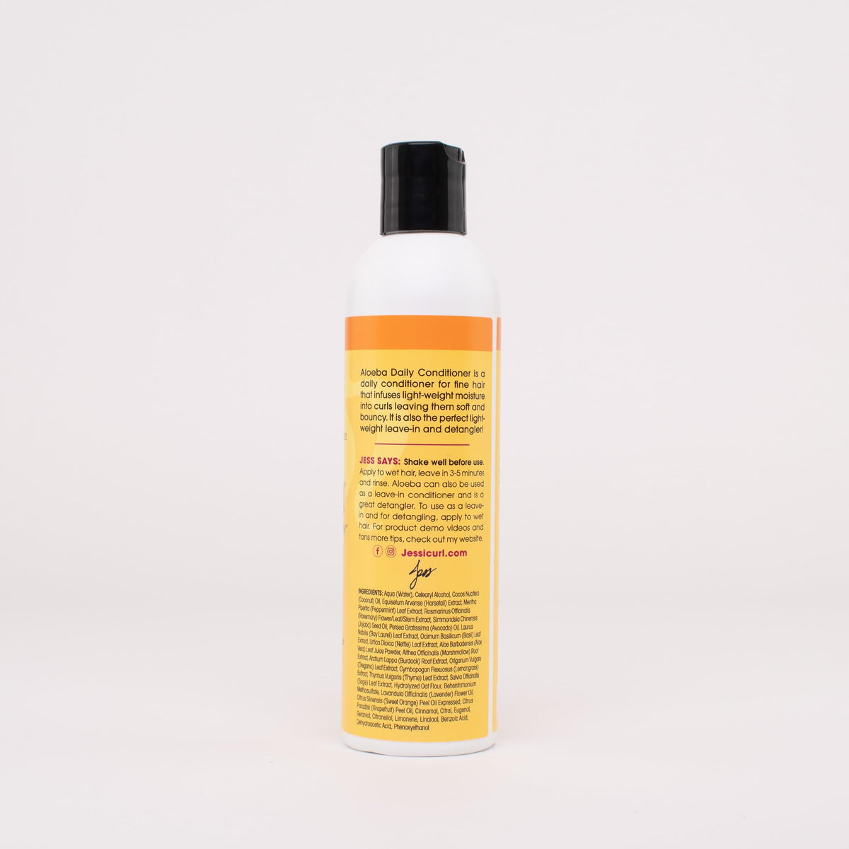 Hands apply Aloeba as leave-in on damp hair for smoother detangling.
