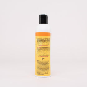 Hands apply Aloeba as leave-in on damp hair for smoother detangling.