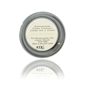 Jo Malone English Pear & Freesia mini cream being applied for travel-friendly moisture.