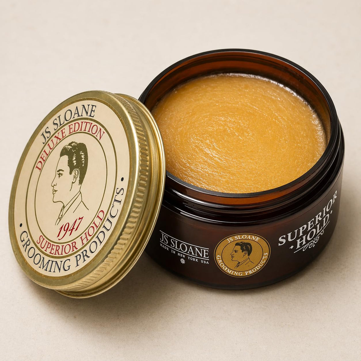 Close-up of the JS Sloane pomade jar highlights creamy texture for smooth application.