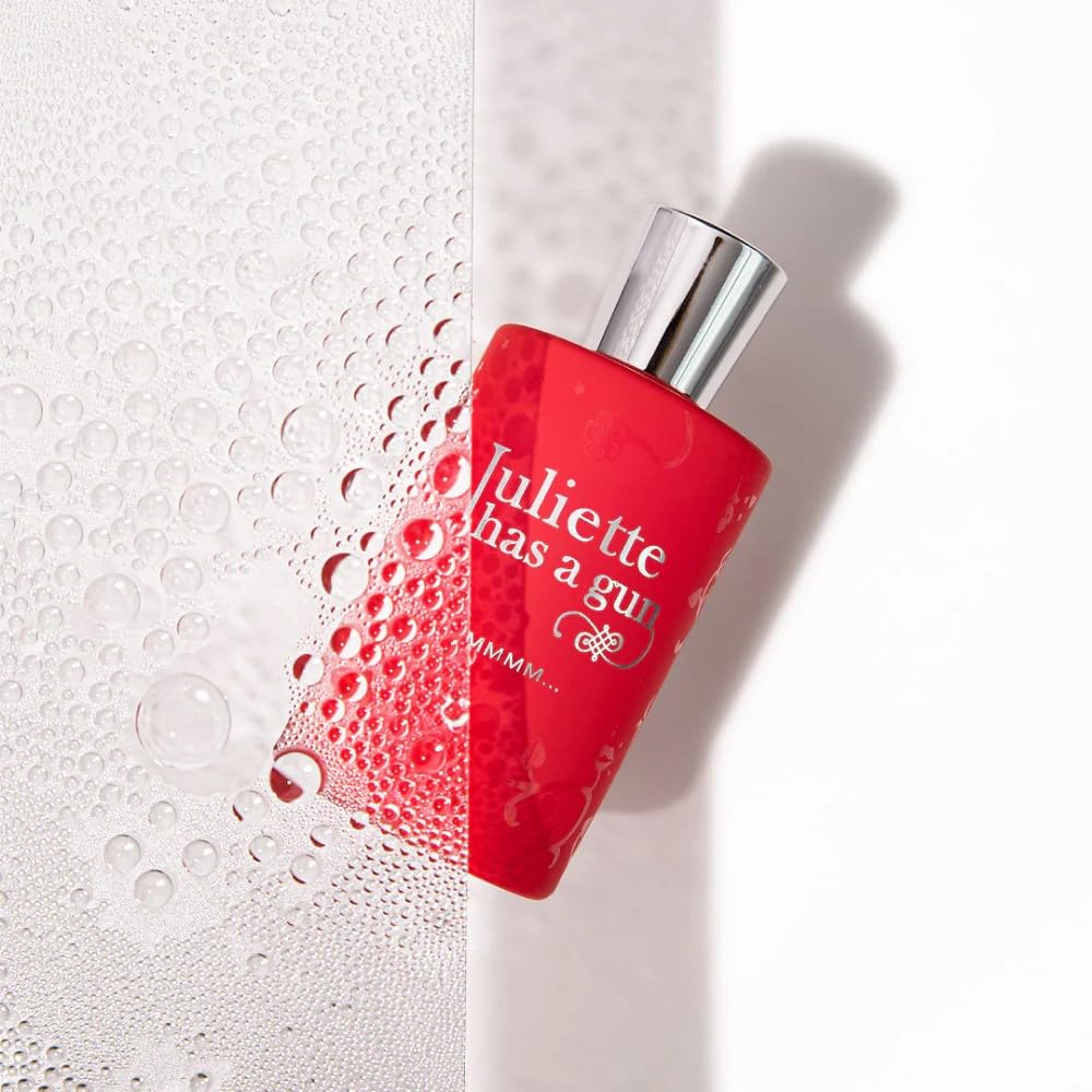 Juliette Has A Gun Mmmm spray bottle releasing scent mist on skin for a first impression.