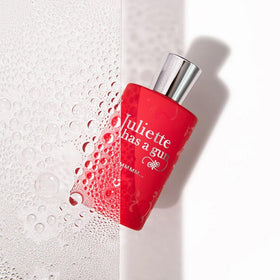 Juliette Has A Gun Mmmm spray bottle releasing scent mist on skin for a first impression.