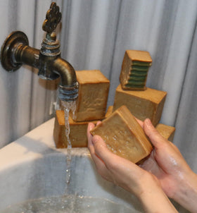 JUSIZA Aleppo Soap in use on hands to moisturize and cleanse.