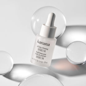 Glass bottle reflection of Karuna All Day Firming Serum signaling premium packaging