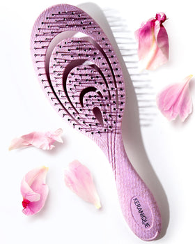 Keranique detangling brush close-up shows smooth glide over tangles for sensitive scalps.
