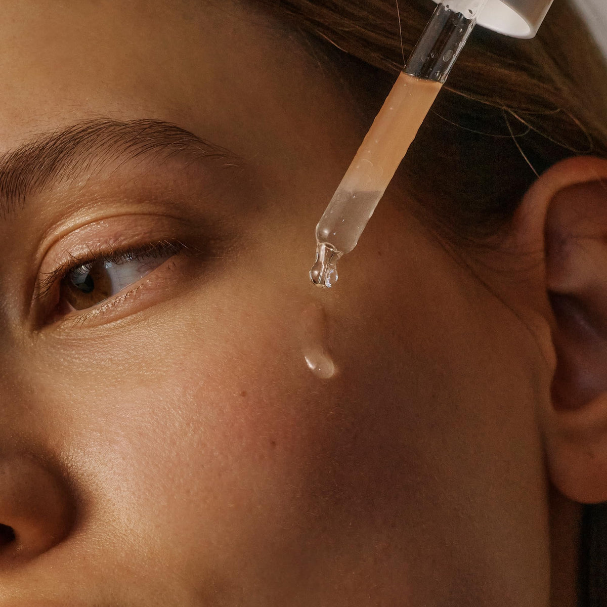 Applying 2–3 drops of Korres Serum to face and neck in routine