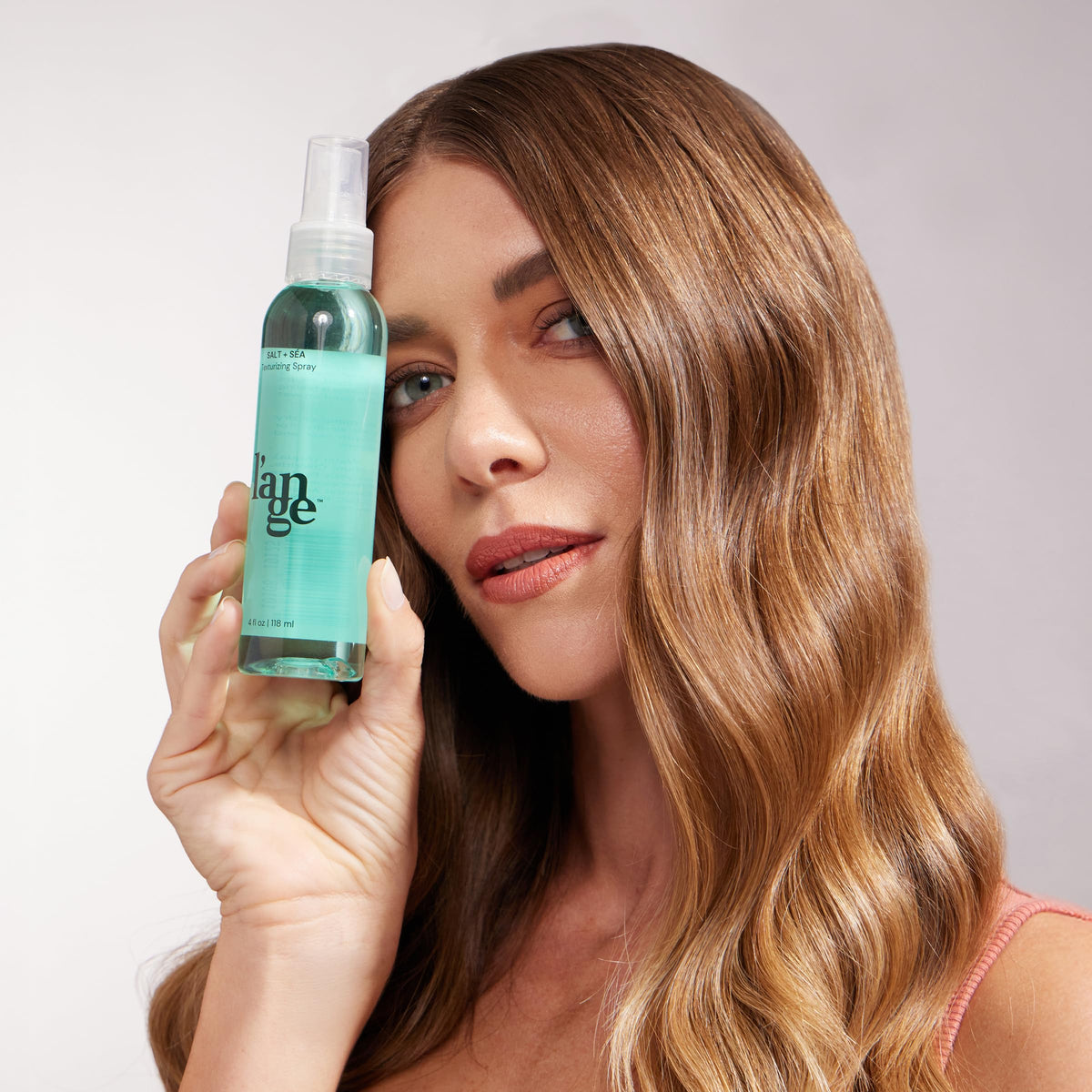 L'ANGE HAIR Sea Salt Texturizing Spray bottle on vanity with kelp-derived care.