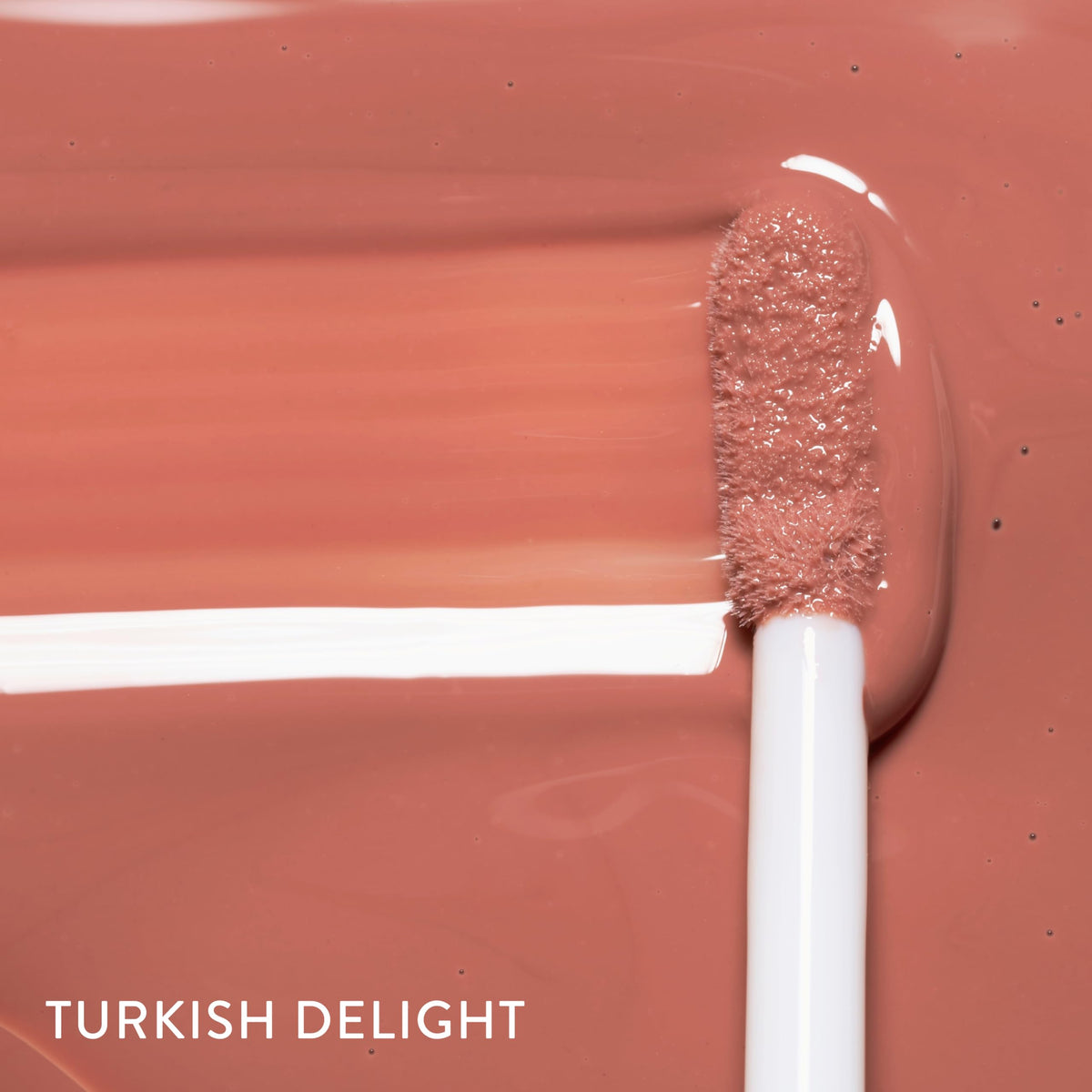 LAURA GELLER Color Luster Lip Gloss Turkish Delight close-up reveals light-reflective shine.