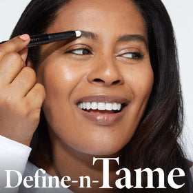 Close-up of wand brushing brows into a lifted silhouette for definition