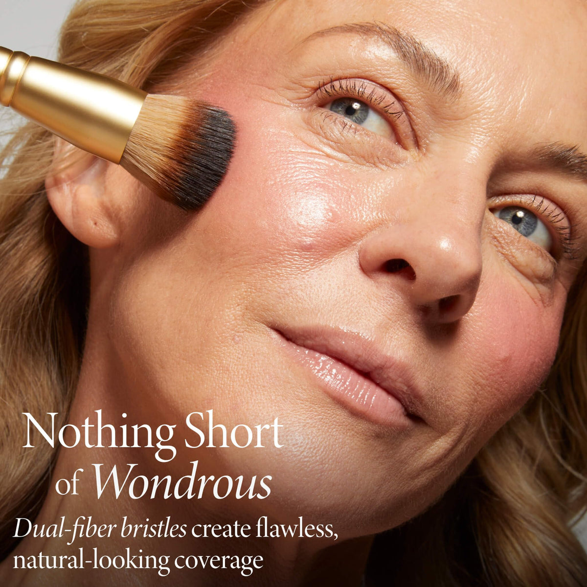 Laura Geller New York Wonder Brush applying Wonder Balm on cheek