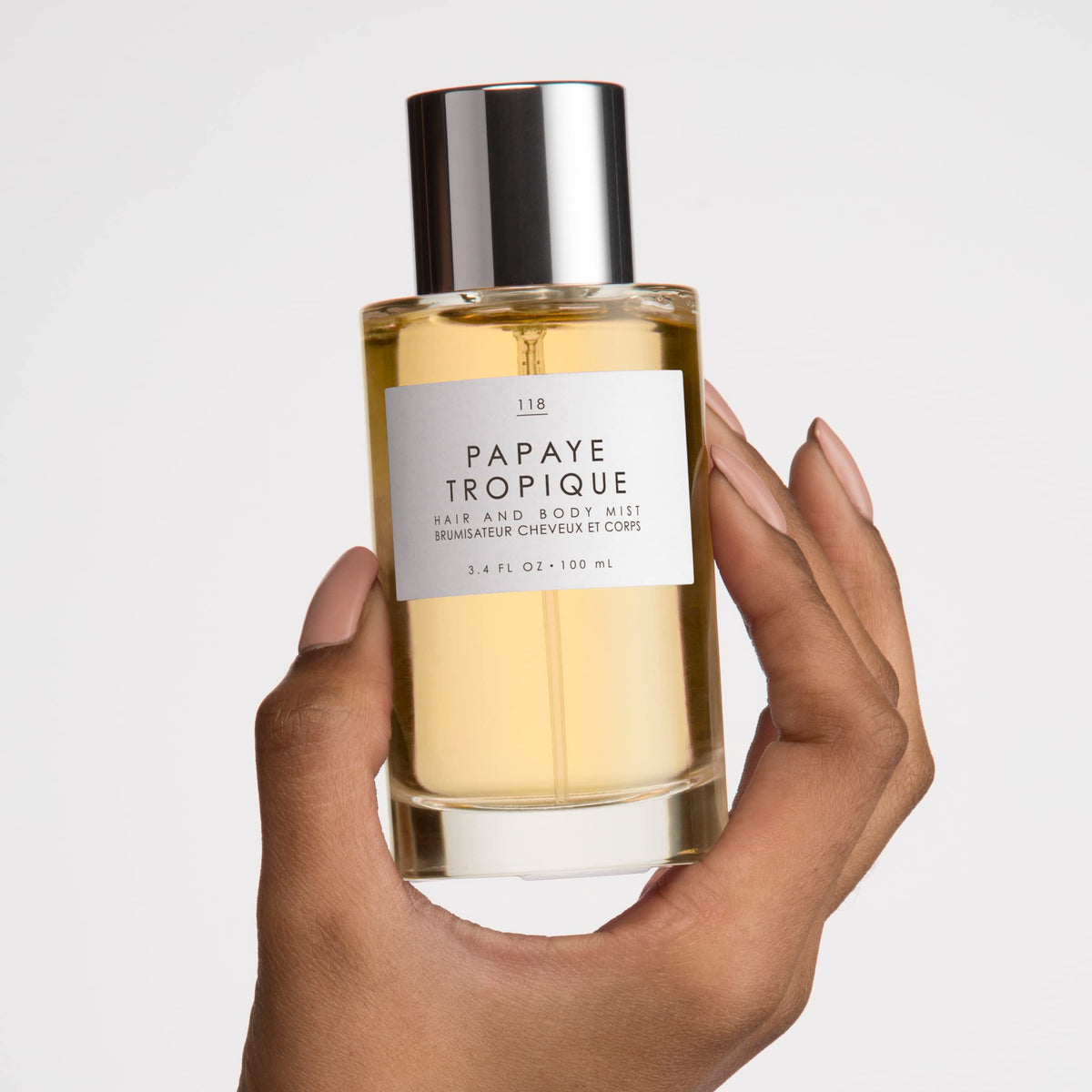 Hair application shot of Le Monde Gourmand Papaya Tropique adding a coconut aura.