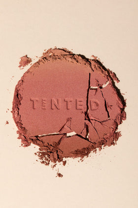 Live Tinted Huebeam application brush tapping the bronzer for contour.