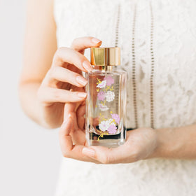 LOLLIA Relax bottle beside flowers evokes a fragrant, calming moment.